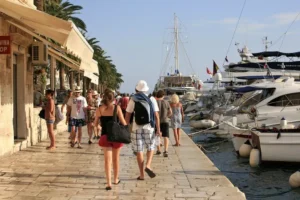 People walking along a coastal town Hvar promenade in Croatia during summer