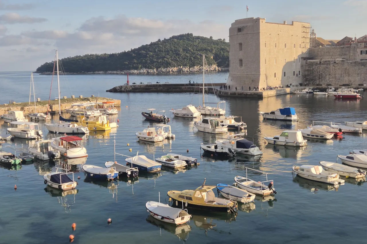Dubrovnik Old Port in spring with small boats, calm water and relaxed atmosphere without crowds