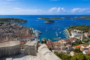 Panoramic view of Hvar Town and harbor from Fortica fortress, with boats, red rooftops and Pakleni Islands in the background, Croatia
