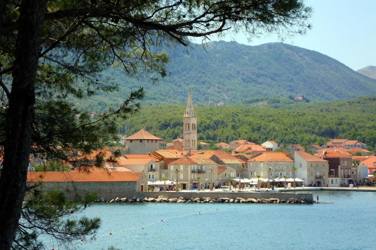 Jelsa waterfront on Hvar island with stone houses and church tower in Croatia