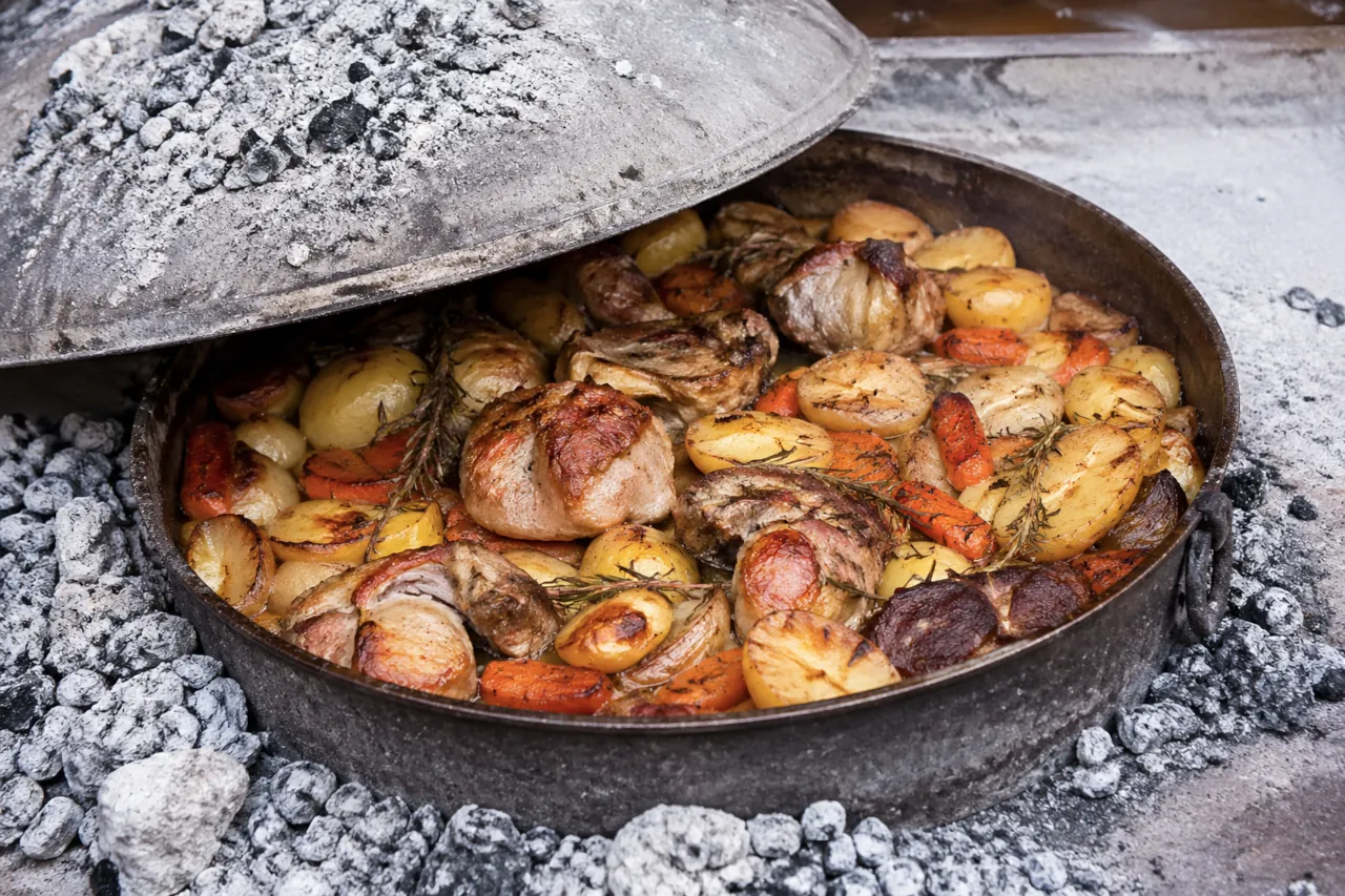 dalmatian-peka-meat-potatoes-open-fire Traditional Dalmatian peka with meat and vegetables prepared under a bell (peka)