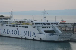 Jadrolinija ferry docked at a port on the Croatian coast during the summer travel season.