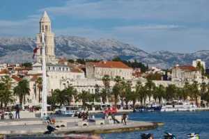 Split Croatia waterfront with Diocletian’s Palace, palm trees and boats along the Riva promenade.