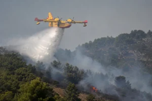 Canadair aircraft dropping water over a wildfire, illustrating the response to the wildfire on Brač