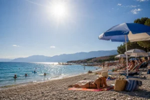 People sheltering from the Croatia heatwave under beach umbrellas on the Adriatic coast