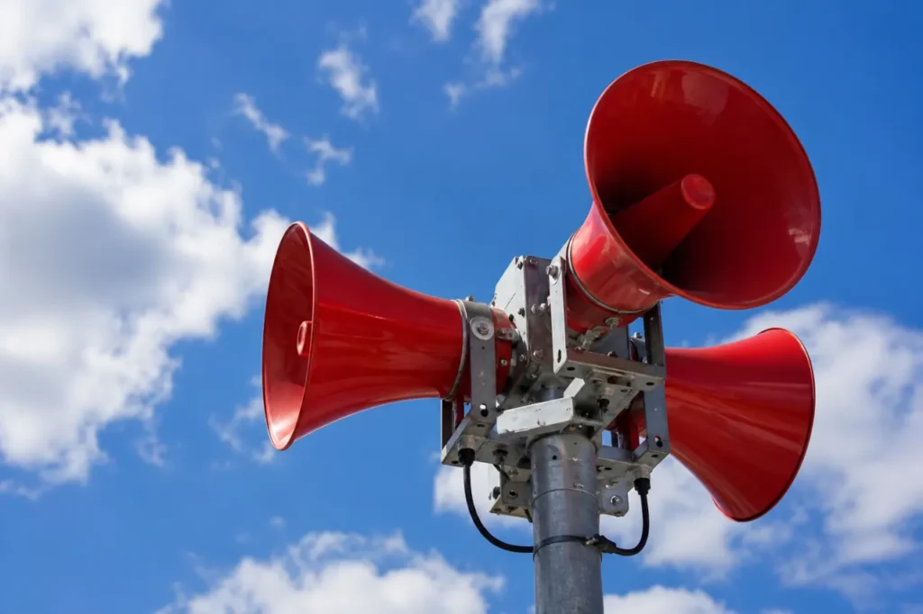 Red warning sirens in Croatia mounted on a pole against a blue sky