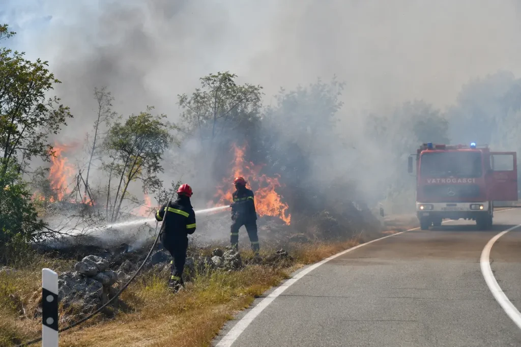 Illustration of firefighters tackling a roadside blaze, accompanying a report on fires in Zadar