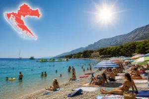 Red heatwave warning in Croatia with people swimming and sunbathing on a crowded beach