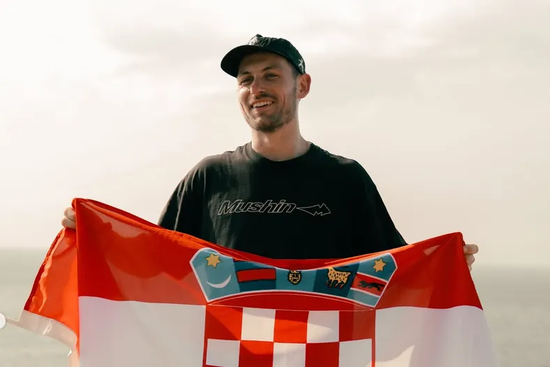 Aydan Papac holding a Croatian flag after completing his run along the Croatian coast